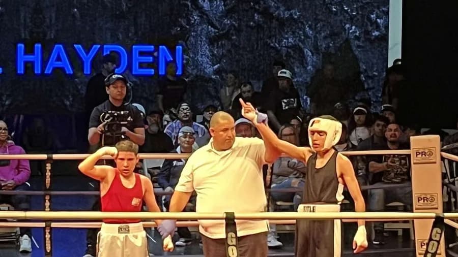 A referee raising a boxer's arm at the end of a bout at a local show